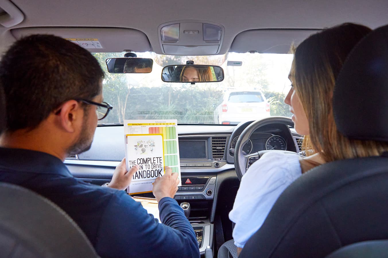 Driving instructor providing real-time guidance while a learner driver practises safe decision-making behind the wheel.