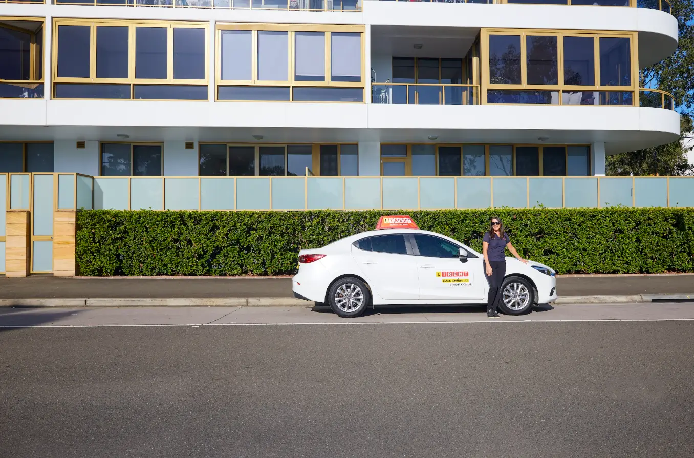 LTrent driving instructor standing beside a learner driver vehicle before a driving lesson.