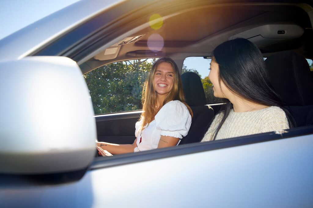 Learner driver building confidence through calm, supportive driving practice with a supervising passenger.