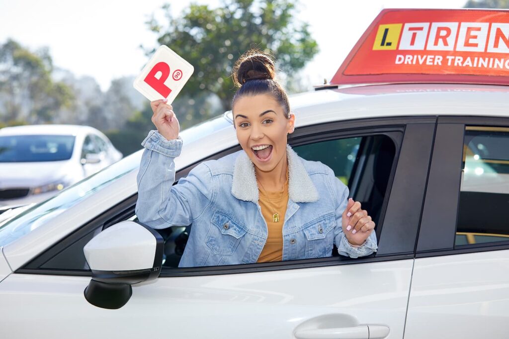 Learner driver celebrating a successful driving milestone after professional training.