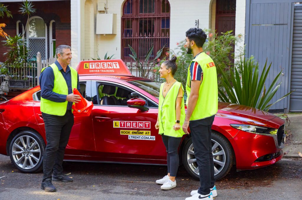 Learner drivers talking with an LTrent instructor before a practical driving lesson.