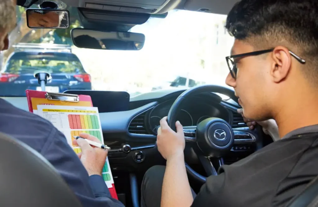 Driving instructor coaching a learner driver during a practical lesson in an automatic vehicle.