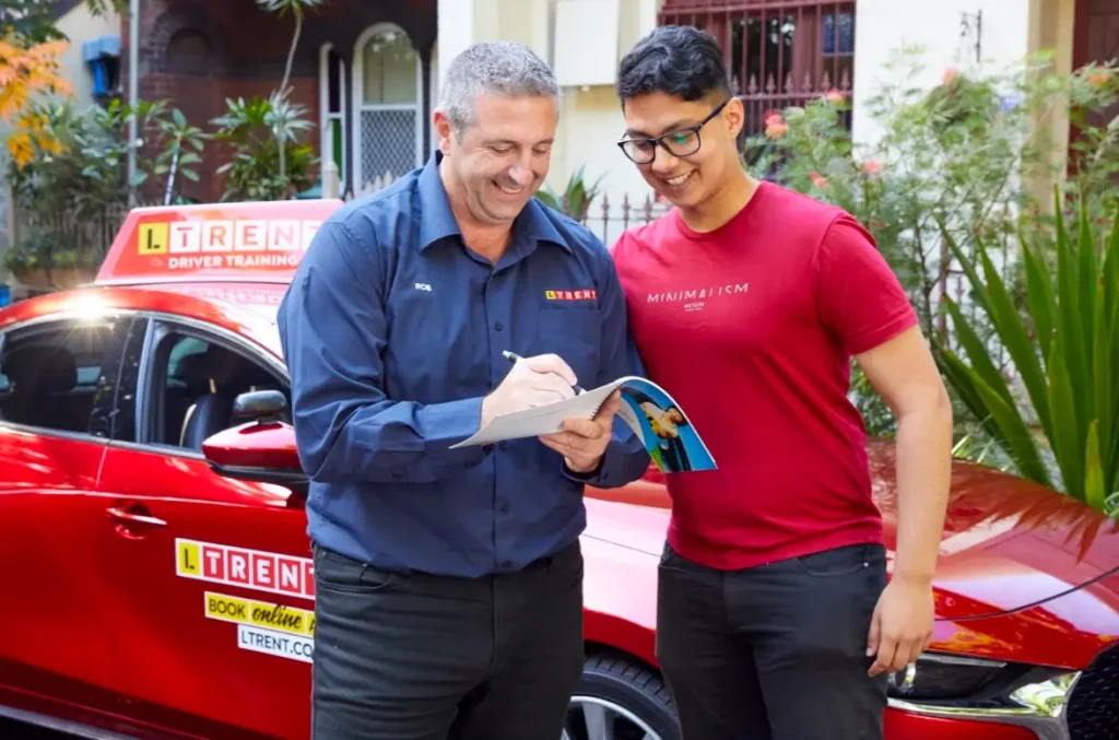 Driving instructor reviewing progress and providing personalised feedback to a learner after a driving lesson.