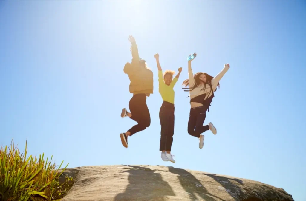 Three friends celebrating after reaching a milestone, representing the confidence and freedom that come with passing your driving test.